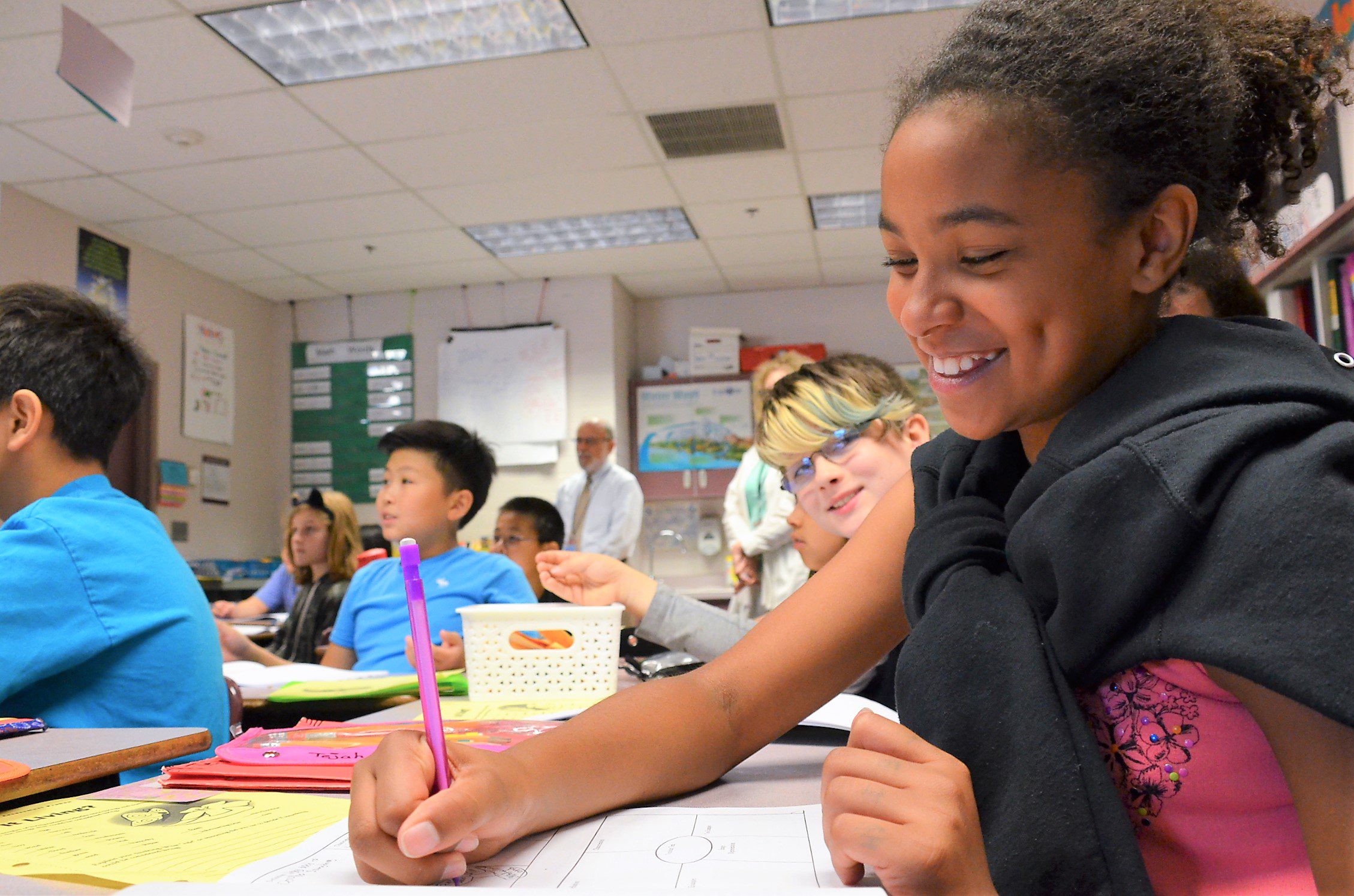 girl in classroom writing