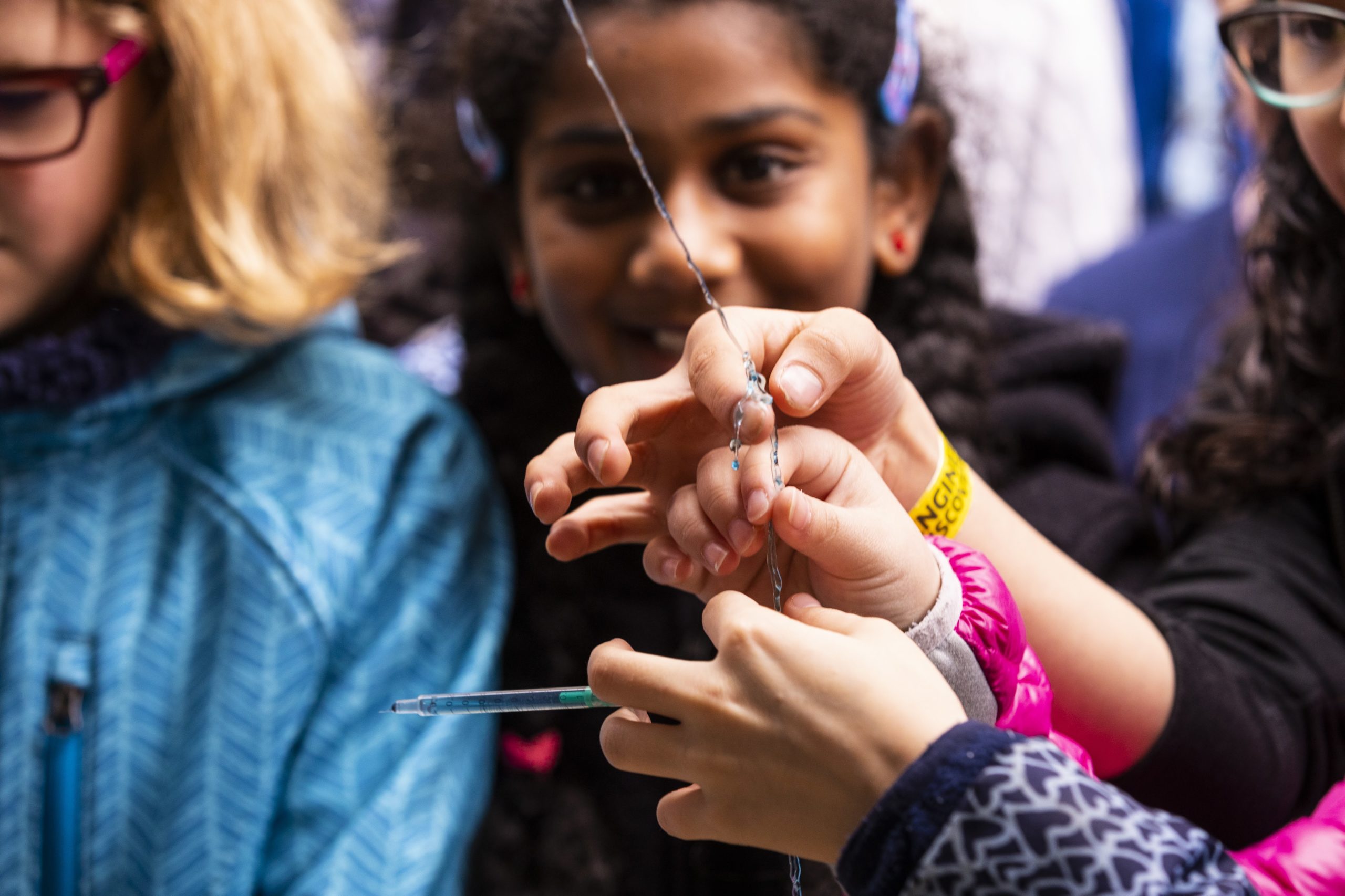 children's hands holding string